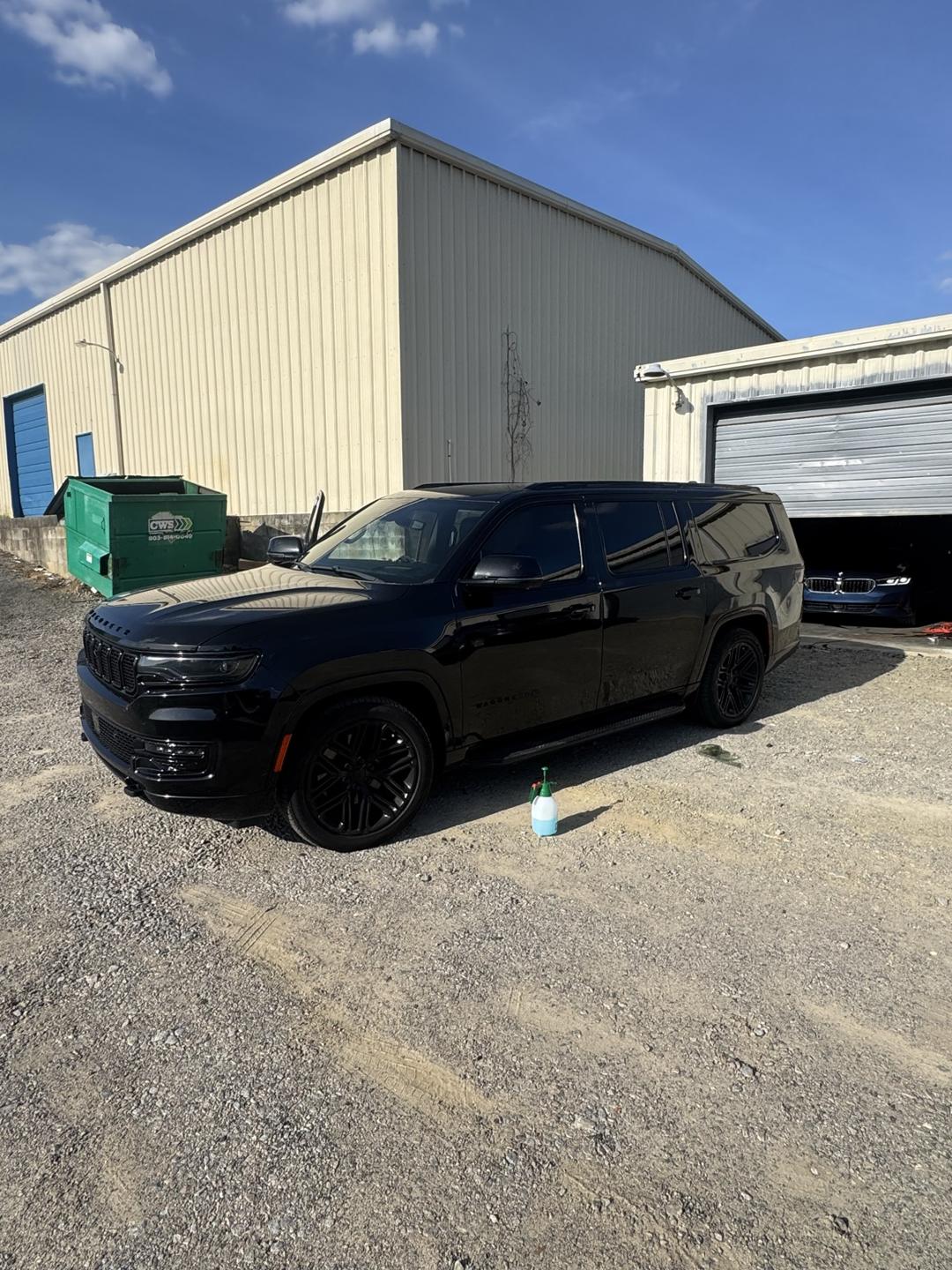 Black SUV with tinted windows parked by the shop