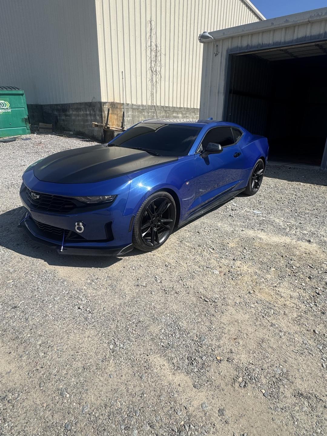 Blue Chevrolet Camaro with tinted windows parked outside the shop