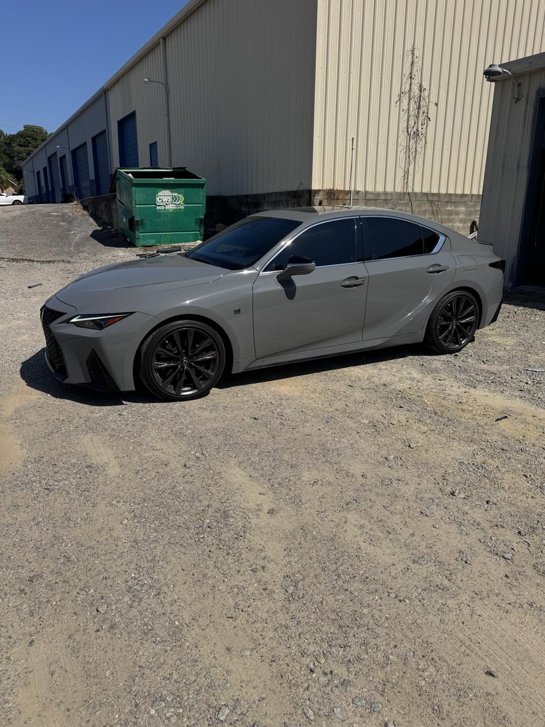 Gray Lexus sedan with tinted windows outside the shop