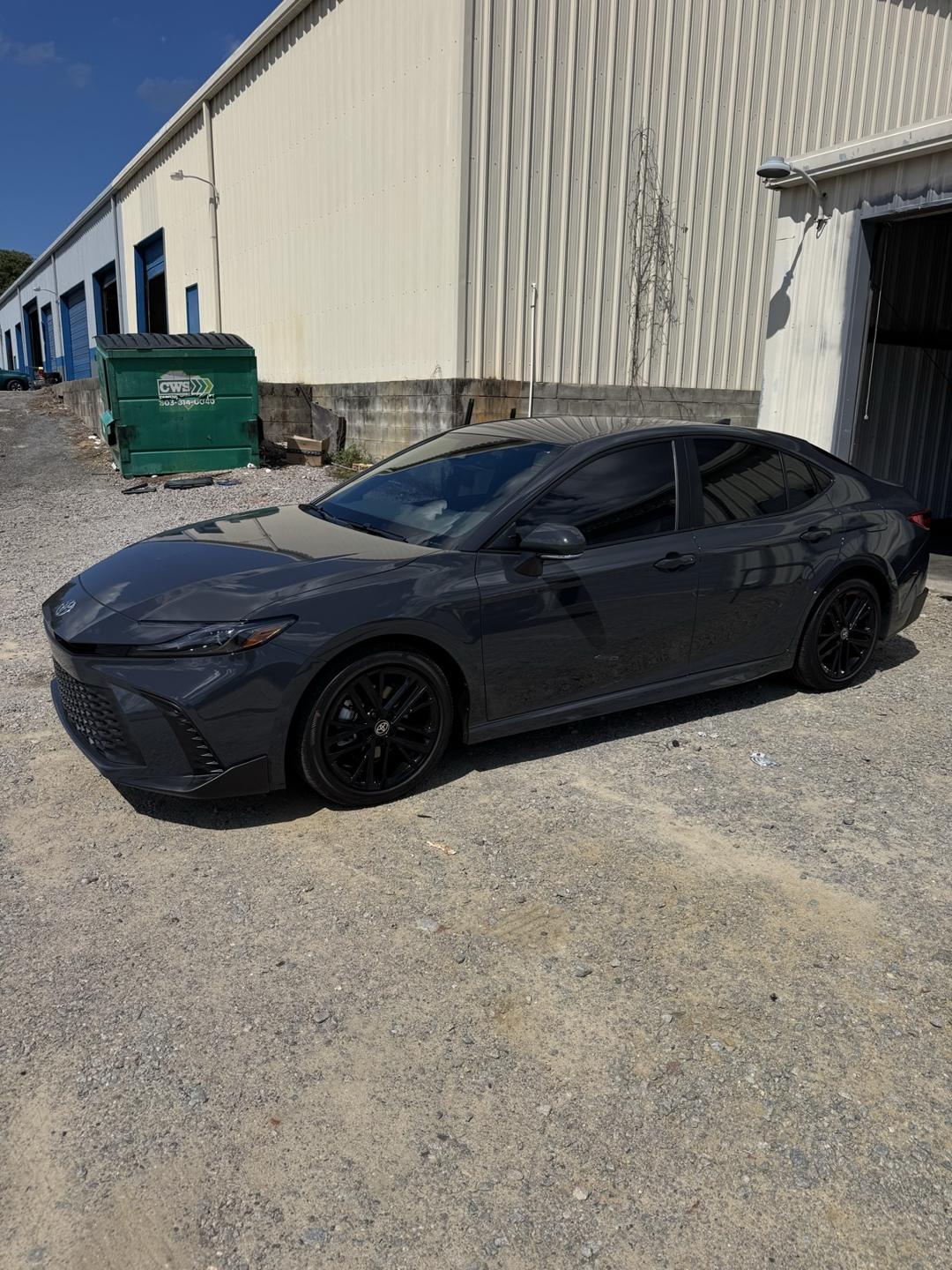 Gray Toyota Camry with tinted windows outside the shop